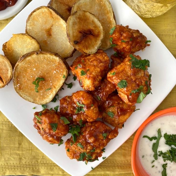 this is a photo of buffalo chicken nuggets on a plate with potatoes