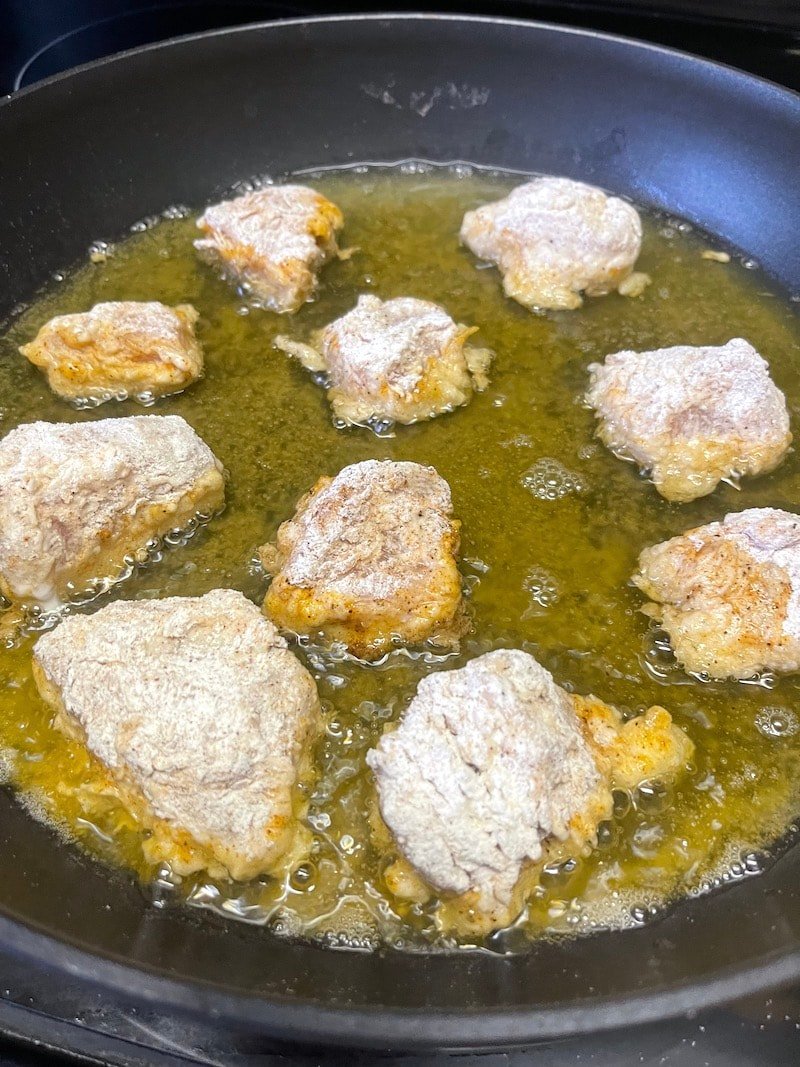 this is a photo of shallow frying chicken nuggets in a skillet