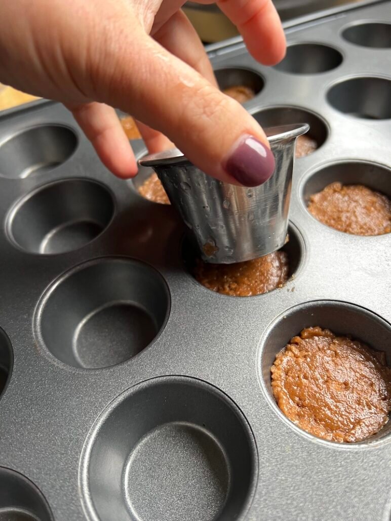 this is a photo of pressing down on the graham cracker crust to parbake