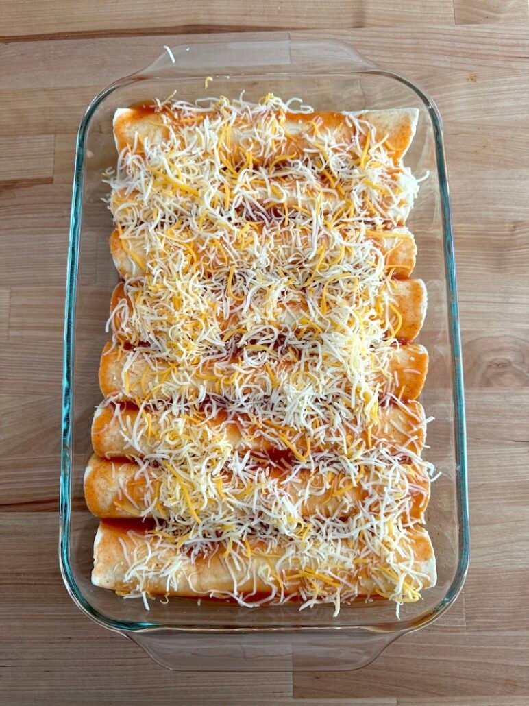 this is a casserole dish with chicken enchiladas ready for the oven