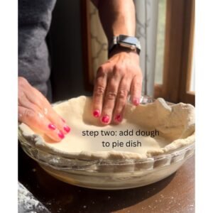 adding pie dough to a pie dish to make quiche