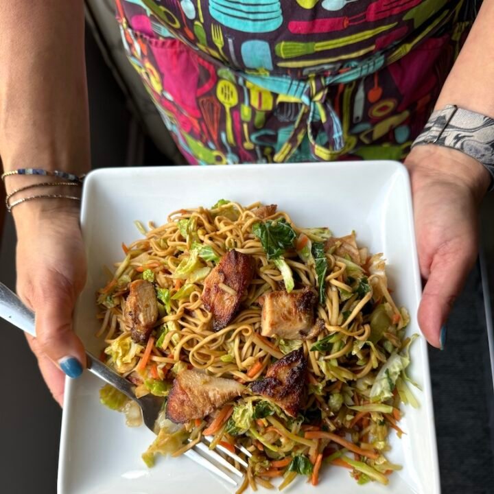 this is a plate of stir fry noodles with chicken and vegetables