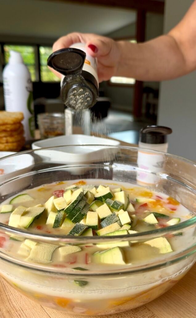 adding seasonings to a breakfast casserole