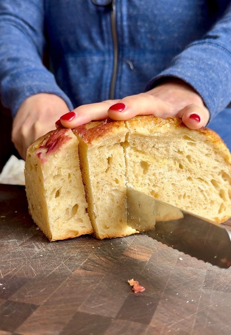sourdough bread being sliced for weight watchers friendly french toast sticks that are perfect for meal prep